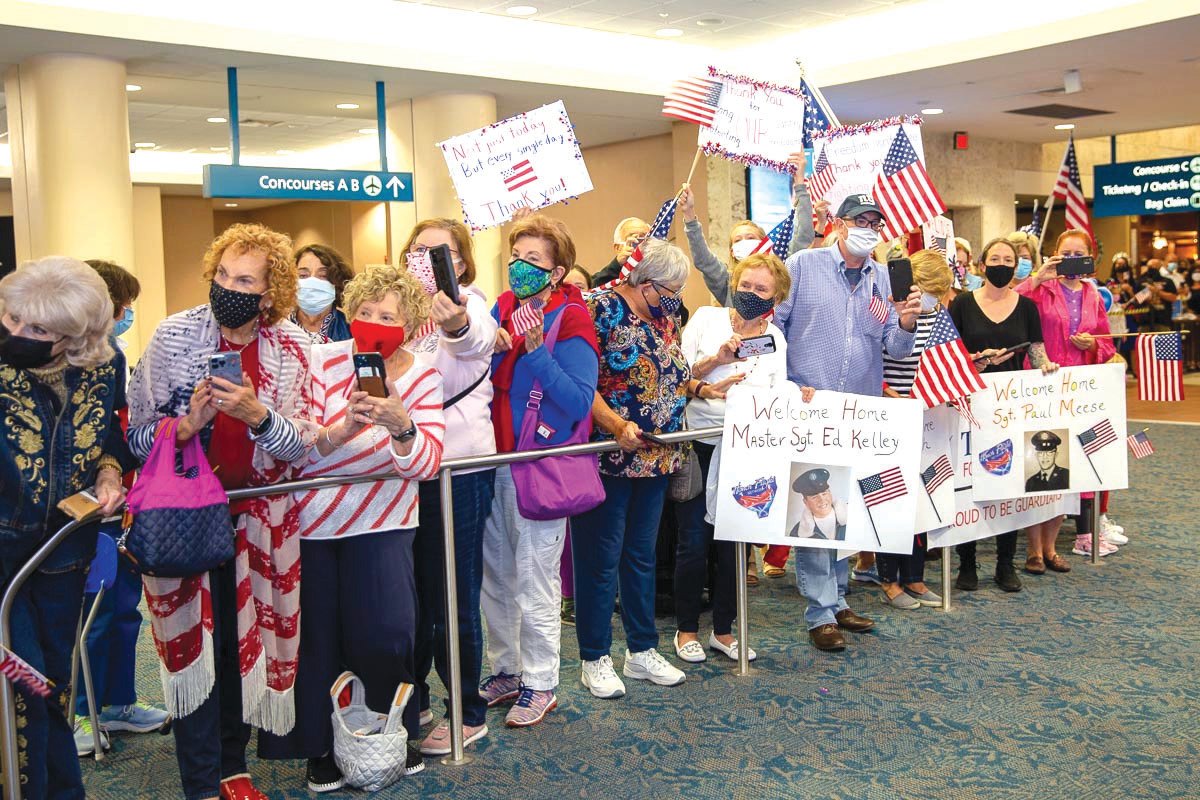 A crowd welcomes Honor Flight veterans return home in April 2021,